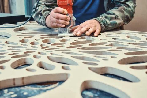 Decorative partition wall with floral pattern. Carpenter milling holes in MDF Stock Photos