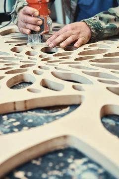 Decorative partition wall with floral pattern. Carpenter milling holes in MDF Stock Photos
