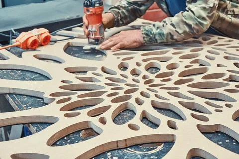 Decorative partition wall with floral pattern. Carpenter milling holes in MDF Stock Photos