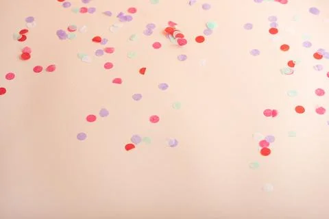 Decorative party light pink background, surrounded by vibrant round confetti Stock Photos