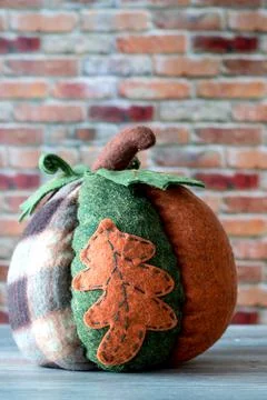Decorative patchwork pumpkin isolated against red brick wall. Thanksgiving co Foto stock