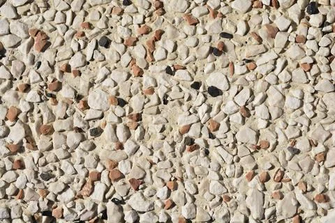 Decorative pebble dash wall texture with white and terracotta stones Foto stock