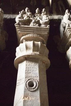 Decorative pillars and scripture in pali of Karla rock cut cave near hills .. Stock Photos