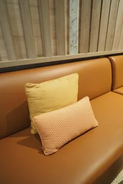 Decorative pillows on a brown sofa in a modern interior space Stock Photos