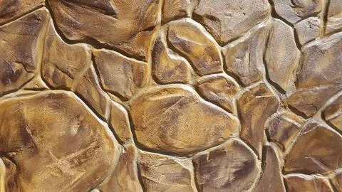 Decorative plaster under a stone. Artificial stone. Vintage background Stock Photos