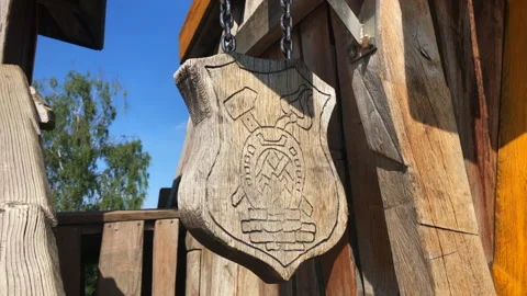 A decorative playground themed blacksmith scutcheon swaying in the wind Stock Footage 162312908