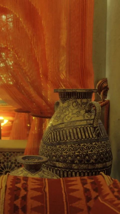 Decorative pottery sits on table in room with orange curtains in evening light Stock Footage 331751318