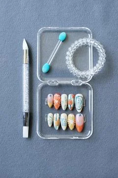 Decorative Press-On Nails with Nail Tools on grey background Stock Photos