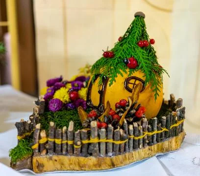 Decorative pumpkin house with natural elements and colorful flowers in fall Stock Photos