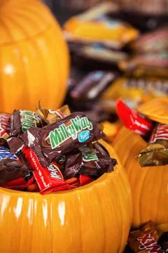 Decorative pumpkins filled with assorted Halloween chocolate candy Foto stock