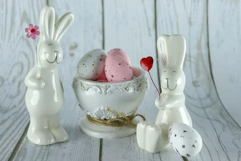 Decorative rabbits and Easter eggs in a decorative vase on a wooden background Stock Photos