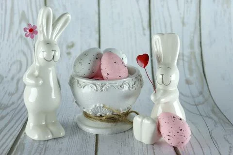 Decorative rabbits and Easter eggs in a decorative vase on a wooden background Stock Photos