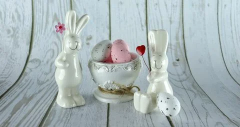 Decorative rabbits and Easter eggs in a decorative vase on a wooden background Stock Photos