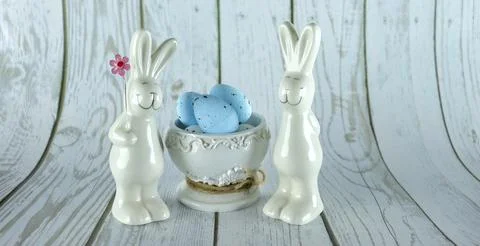 Decorative rabbits and Easter eggs in a decorative vase on a wooden background Stock Photos