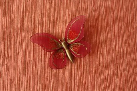 Decorative red butterfly decoration on textured orange background Stock Photos