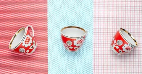 Decorative red cups with white patterns on colorful backgrounds Stock Photos