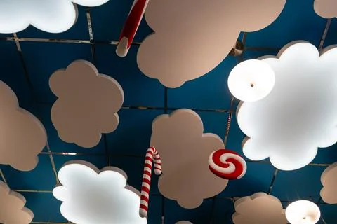 Decorative room ceiling features hanging white light panels shaped like cloud Fotos Stock