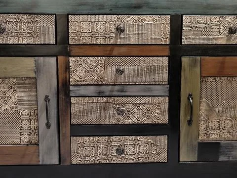 Decorative rustic storage unit featuring textured drawers and antique metal.. 스톡 사진