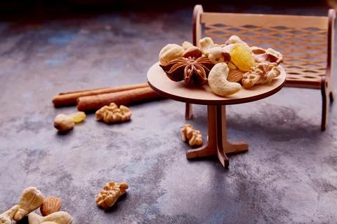 Decorative serving of mixed nuts on small furniture. Healthy desserts and snacks Foto stock