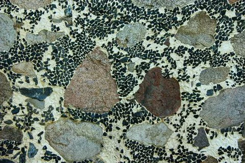 Decorative stone mosaic wall pattern with natural rock and dark fragments Foto stock