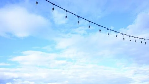 Decorative string light hanging outdoors under a clear daylight sky Stock Photos