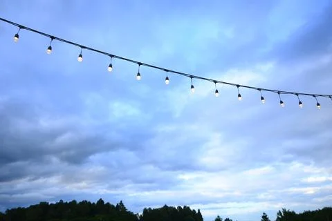 Decorative string light hanging outdoors under a clear daylight sky 库存照片