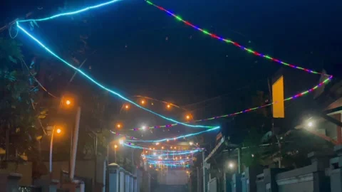 Decorative string lights hanging across residential alley at night Video stock 341897856