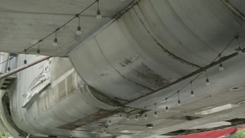 Decorative string lights hanging under a rusted airplane fuselage 動画素材 337384673
