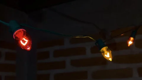 Decorative string lights illuminating brick wall, creating warm ambiance for Stock Footage 340863220