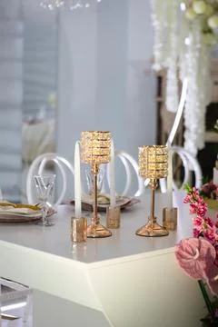 Decorative table setting with candles and flowers in a bright indoor space .. Stock Photos