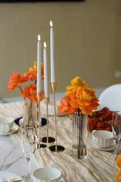 Decorative table setting with flowers and candles in a modern dining area d.. Stock Photos
