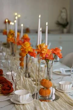 Decorative table setup with flowers and candles for a gathering during autumn Stock Photos