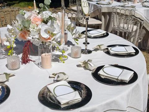 Decorative table setup for an outdoor event with flowers and elegant dinner.. Stock Photos