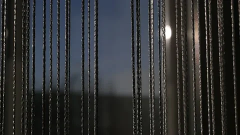 Decorative thread curtains on a window on a sunny day, close up Stock Footage 166549406