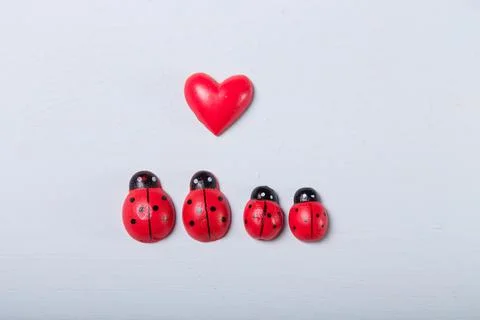 Decorative tiny red ladybugs with red heart on fair background. Love 스톡 사진