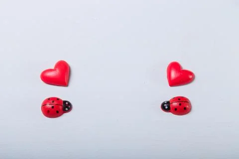 Decorative tiny red ladybugs with red hearts on fair background. Spring 스톡 사진