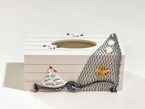 Decorative tissue box adorned with seashells, rope, and miniature boat in mariti Foto stock