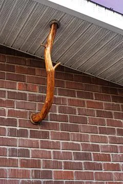 Decorative tree branch support on brick building wall Stock Photos