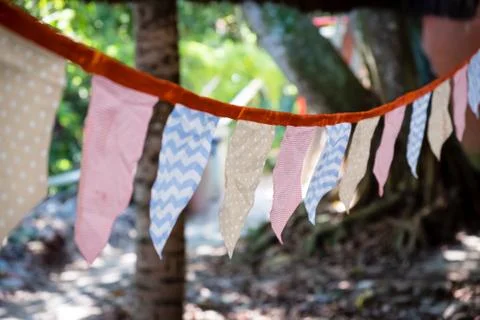 Decorative triangular and square party flags and lamps on trees, toned and wi 写真素材