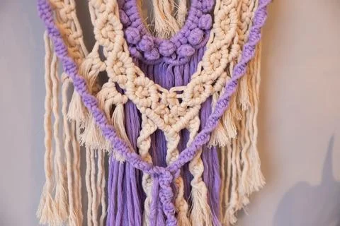 Decorative wall macrame design in purple and beige colors. intricate knots Stock Photos