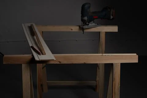 Decorative wall panel board and jigsaw positioned on workbench before cutting Stock Photos
