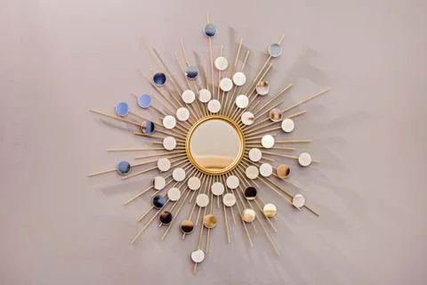 Decorative wall round mirror in the shape of the sun, a golden cooper mirror, Foto stock