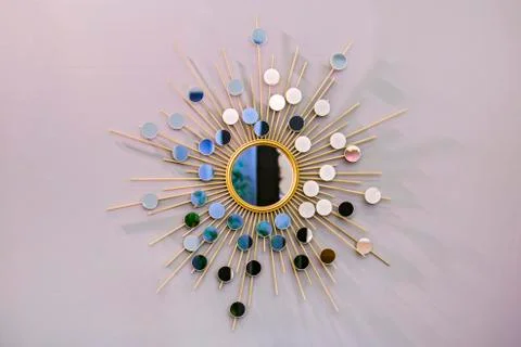 Decorative wall round mirror in the shape of the sun, a golden cooper mirror, Stock Photos