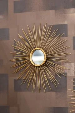 Decorative wall round mirror in the shape of the sun, a golden cooper mirror, Stock Photos