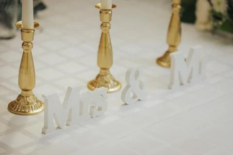 Decorative wedding table setting featuring golden candlesticks and white wo.. Stock Photos