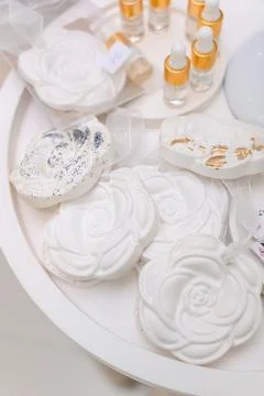 Decorative white rose-shaped soaps with essential oil bottles on display Stock Photos
