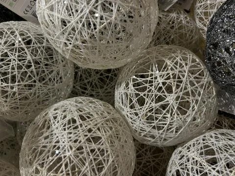 Decorative white string spheres with glittered woven thread forming hollow 스톡 사진