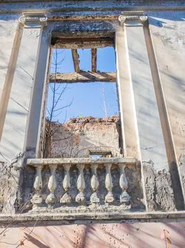 Decorative window opening with columns and balusters in an old ruined abandoned Stock Photos