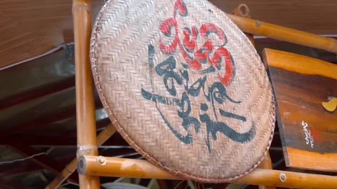 A decorative woven bamboo flat winwaying basket with red and black calligraphy Stock Footage 340631162