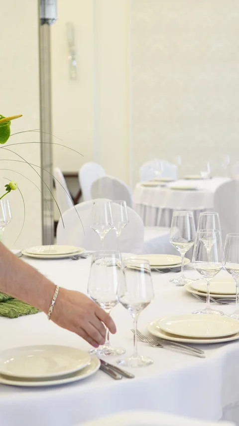 Decorator serving a white wedding table in a restaurant. placing a glass Stock Footage 318932159